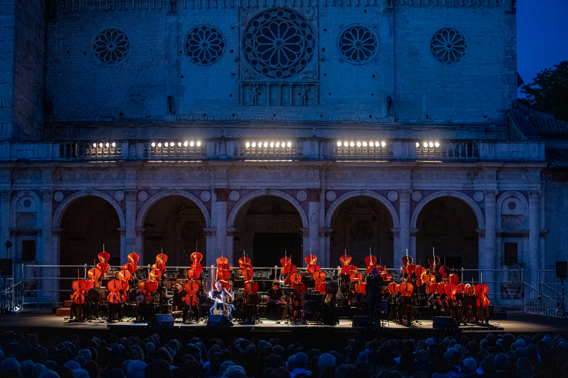 Festival di Spoleto: Vibrant orchestra performance with red-clad musicians at night