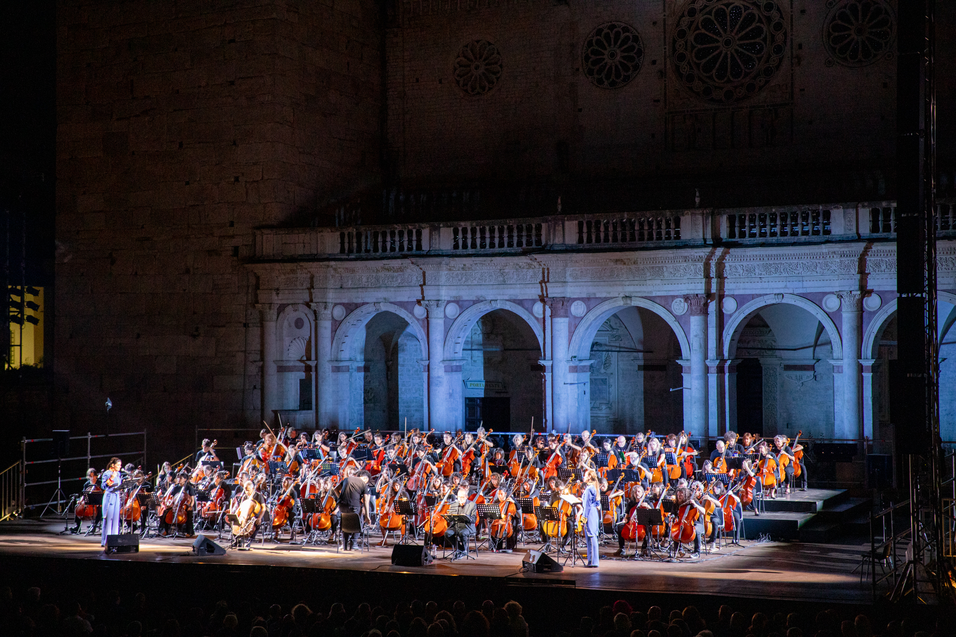 Large orchestra performing at Festival di Spoleto in historic architectural setting