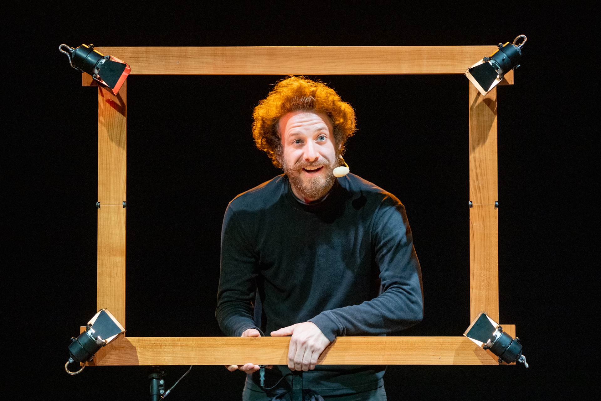 Performer at Festival di Spoleto with curly hair inside wooden stage frame