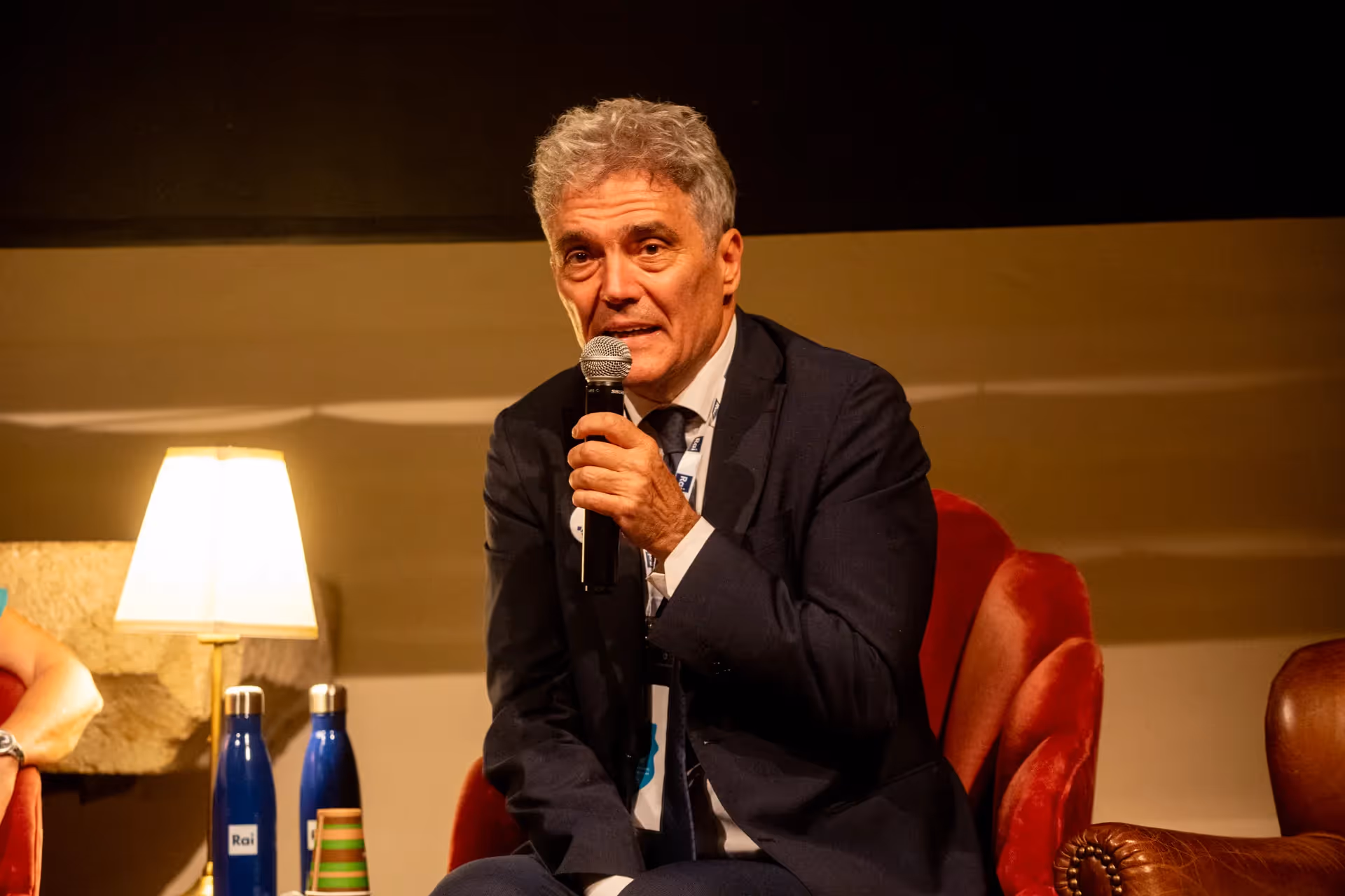 Intervento al Festival di Spoleto, relatore con microfono su poltrona rossa