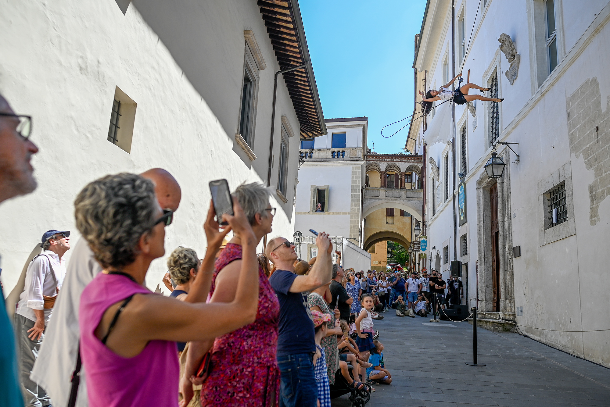 Performer sospeso durante il Festival di Spoleto, pubblico affascinato nelle strette vie storiche