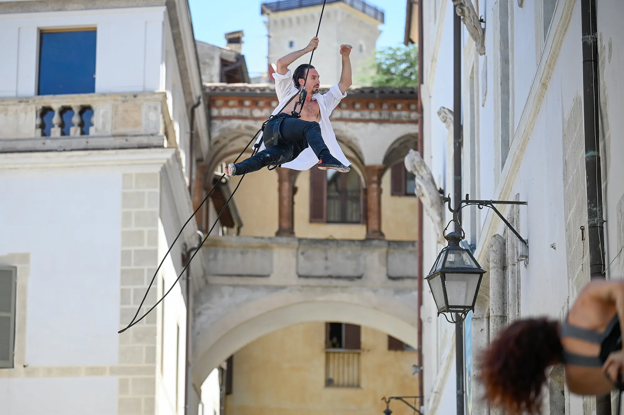 Aerial performer suspended mid-air during Festival di Spoleto street performance