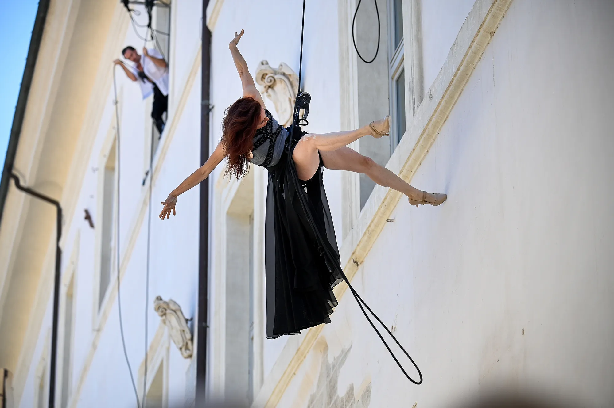 Aerial dancer suspended at Festival di Spoleto, performing dramatic wall choreography