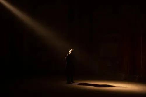 Solista illuminato sotto riflettore al Festival di Spoleto, atmosfera drammatica