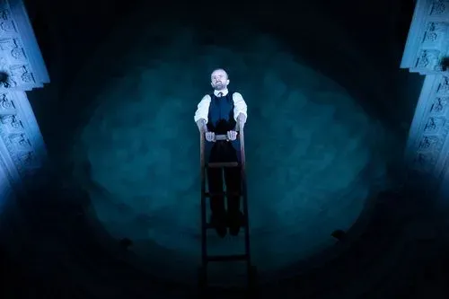 Performer su scala al Festival di Spoleto, illuminato da luce drammatica