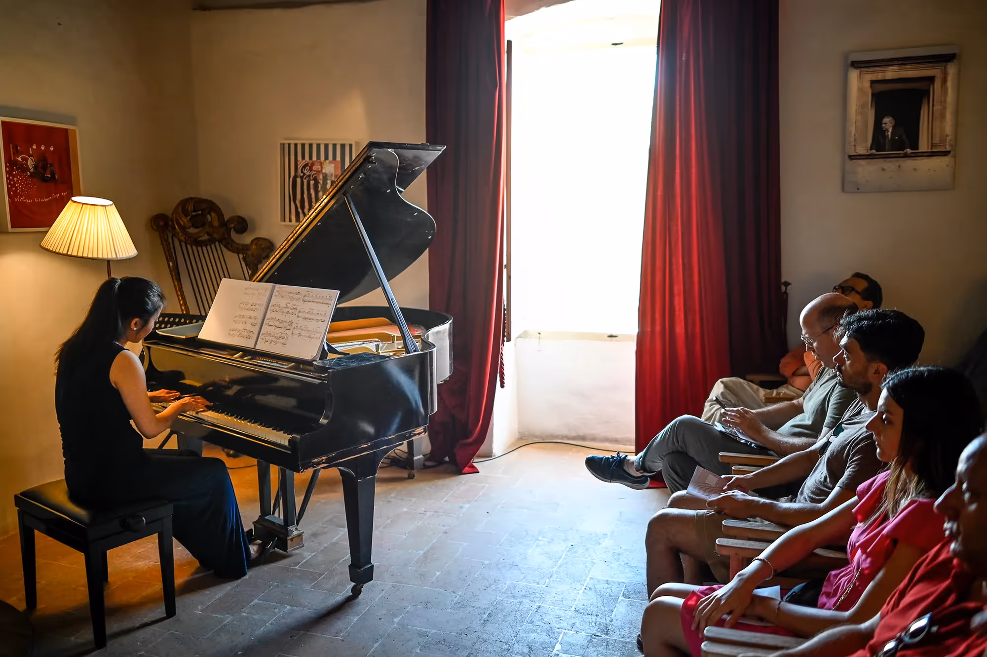Pianist performing at Festival di Spoleto, audience listening intently in intimate setting