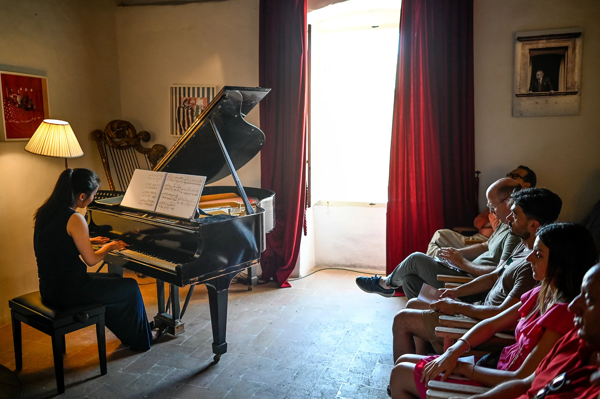 Pianist performing at Festival di Spoleto, audience listening intently in intimate setting