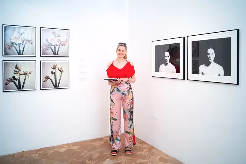 Mostra artistica al Festival di Spoleto con visitatrice in rosso e nero