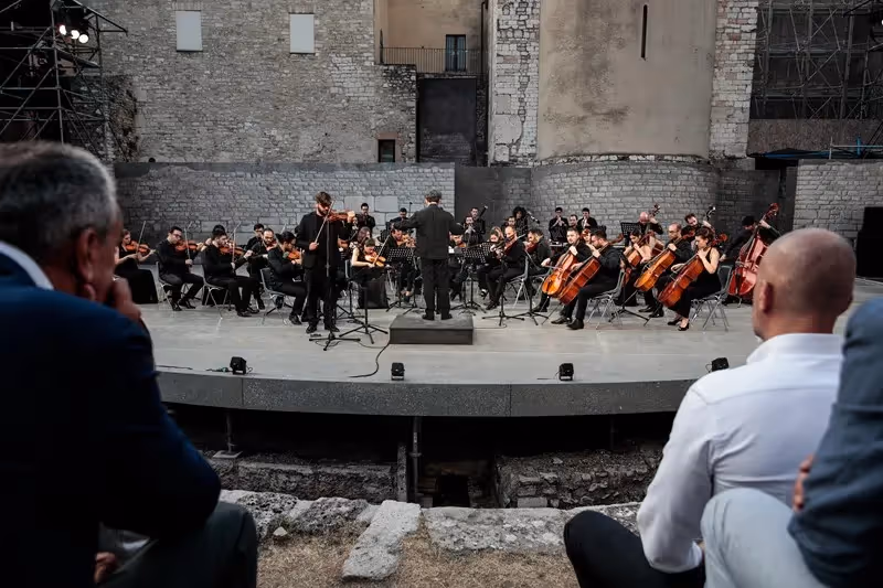 Orchestra sinfonica si esibisce al Festival di Spoleto, scenario architettonico suggestivo
