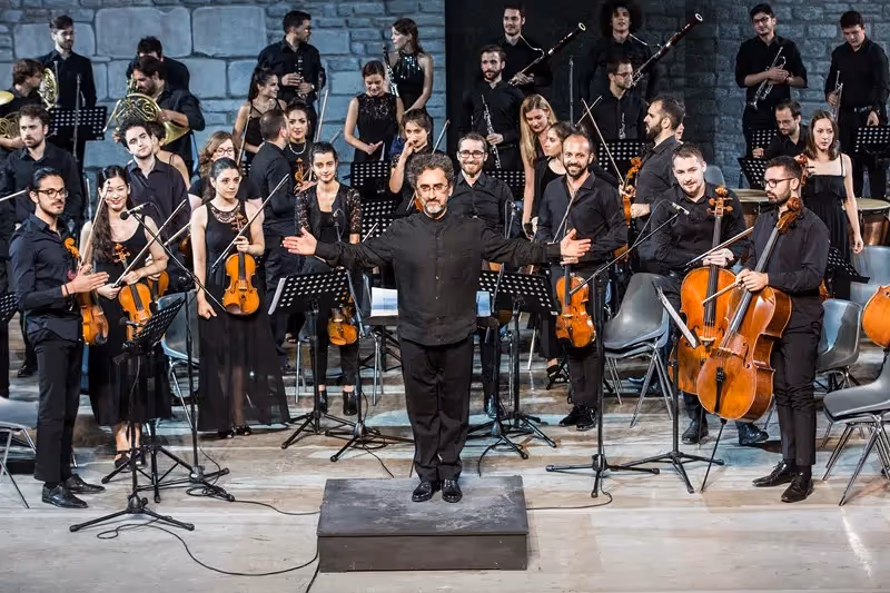 Orchestra al Festival di Spoleto, musicisti in nero eseguono un concerto emozionante