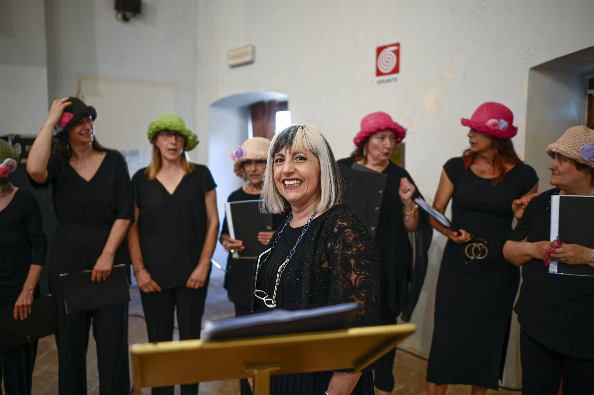Joyful group at Festival di Spoleto wearing colorful hats and black outfits