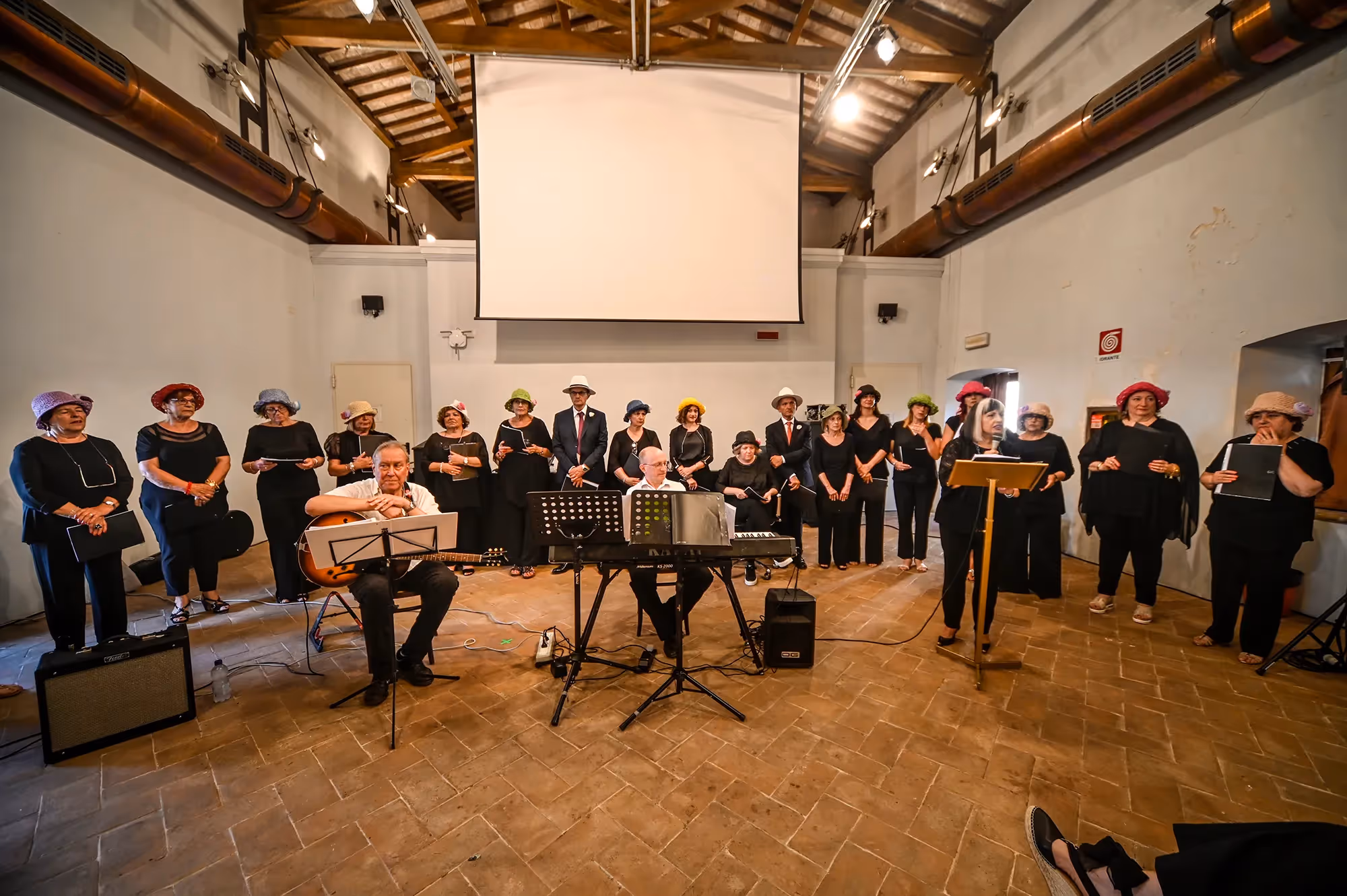 Esibizione corale al Festival di Spoleto, musicisti in nero con cappelli