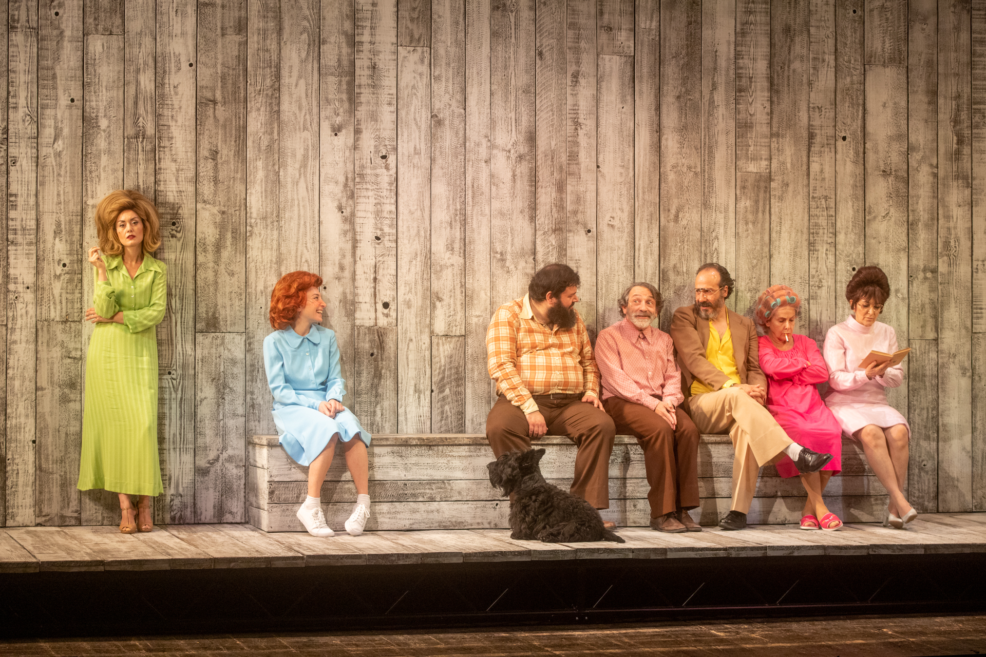 Scena teatrale colorata al Festival di Spoleto con attori seduti su una panchina