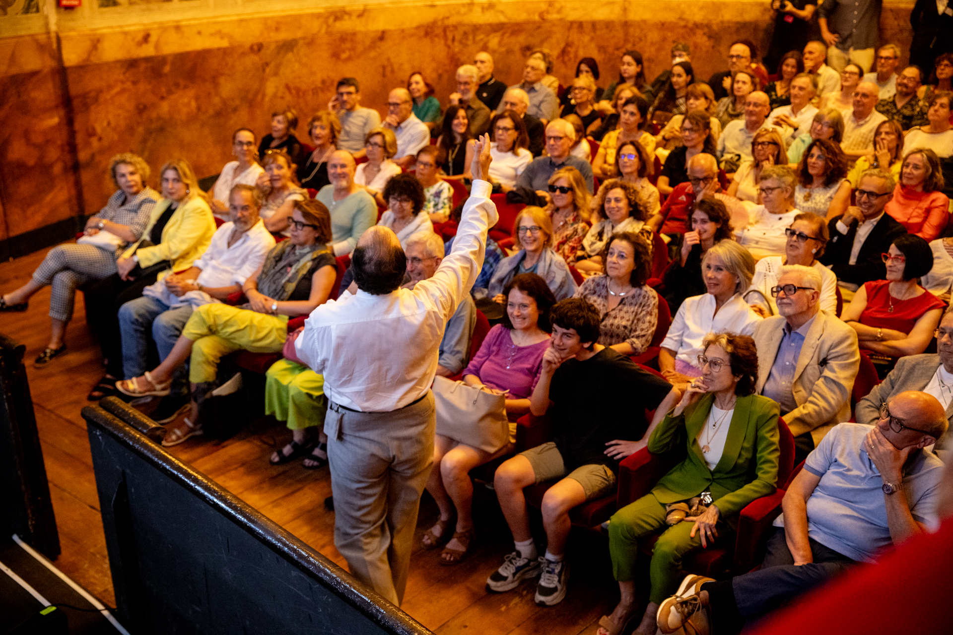 Crowded audience at Festival di Spoleto event with speaker raising hand