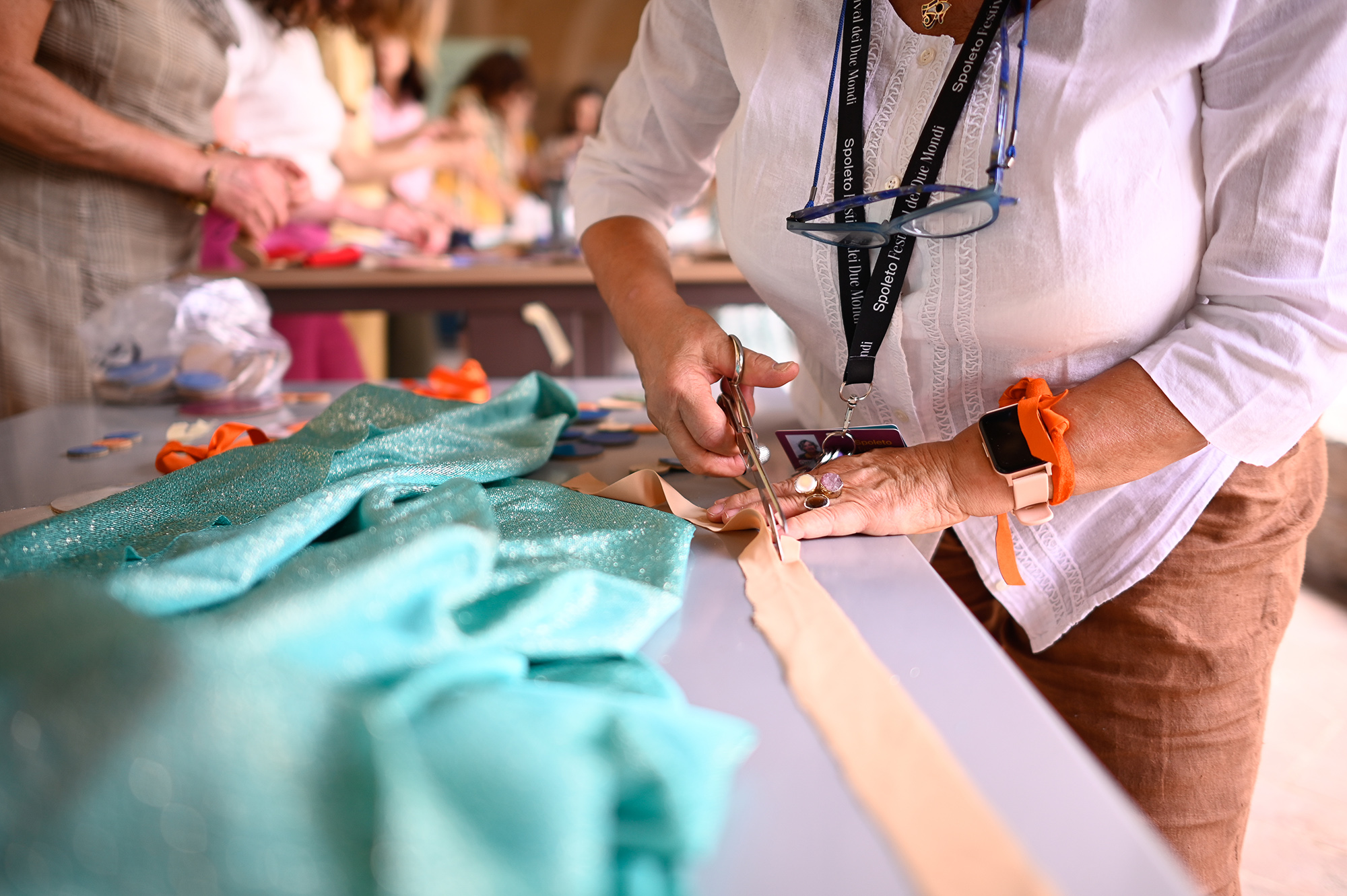 Crafting at Festival di Spoleto, hands cutting fabric with colorful materials