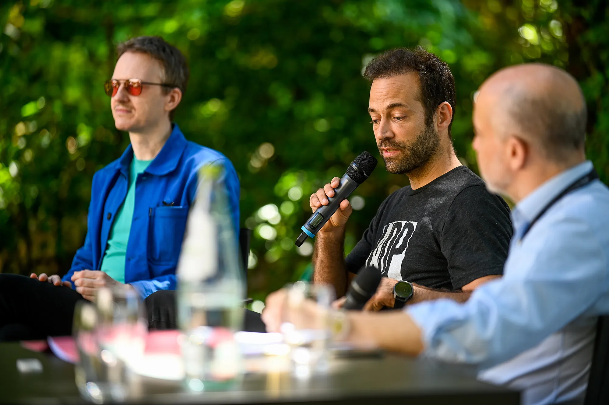 Speakers at Festival di Spoleto panel discussion outdoors with microphones
