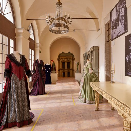 Vintage dresses on display at Festival di Spoleto exhibit in elegant hall