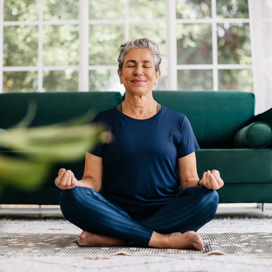 woman practicing meditation while sitting on floor