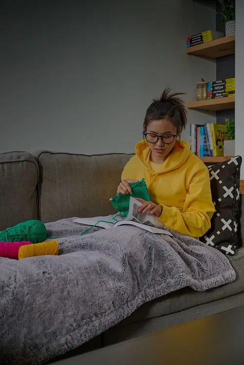 woman learning how to knit by reading for dummies book