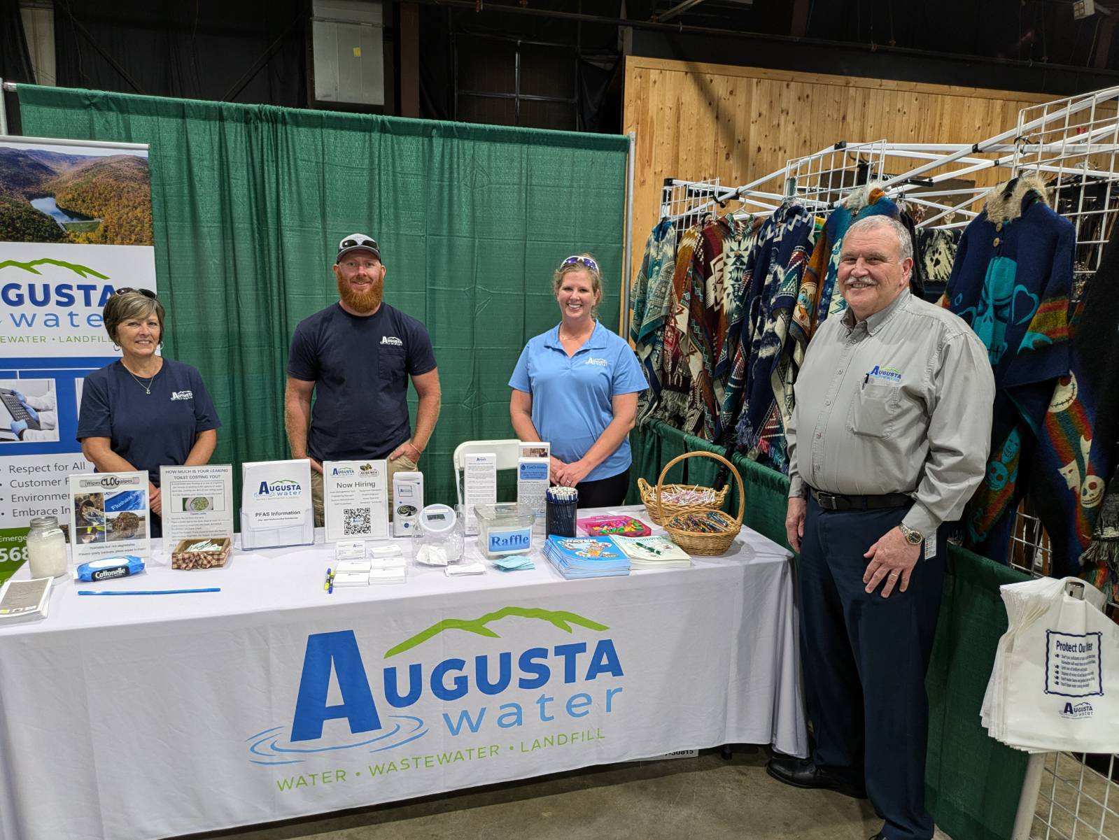 Augusta water personnel at a conference with a tale setup with provided information