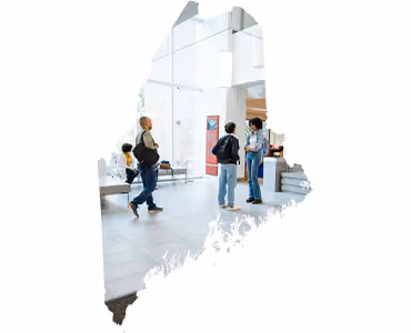 People walking in modern, bright, glass-walled museum or gallery space