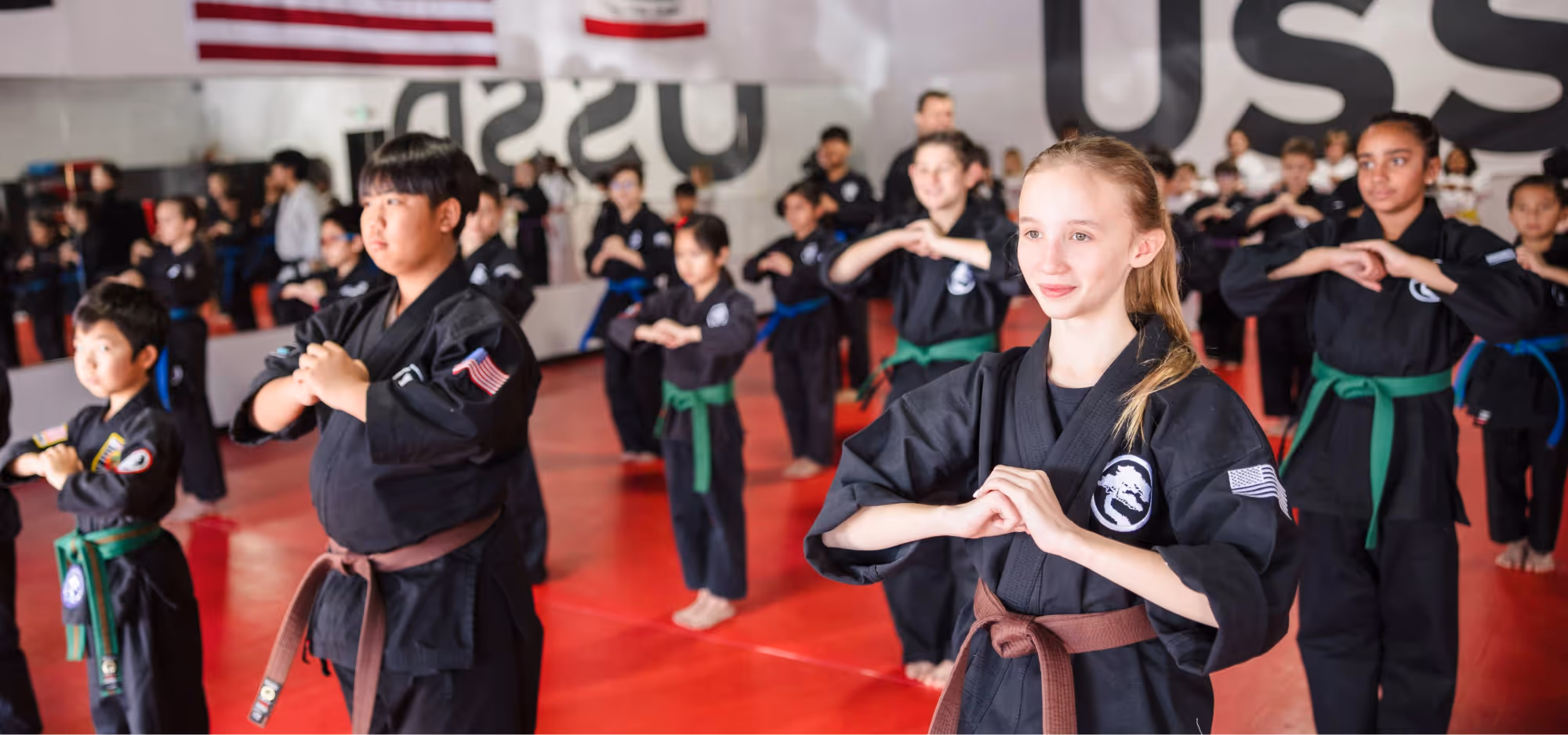 Rows and rows of karate class students stand ready in the front position as they wait for the sensei to start the next part of class.