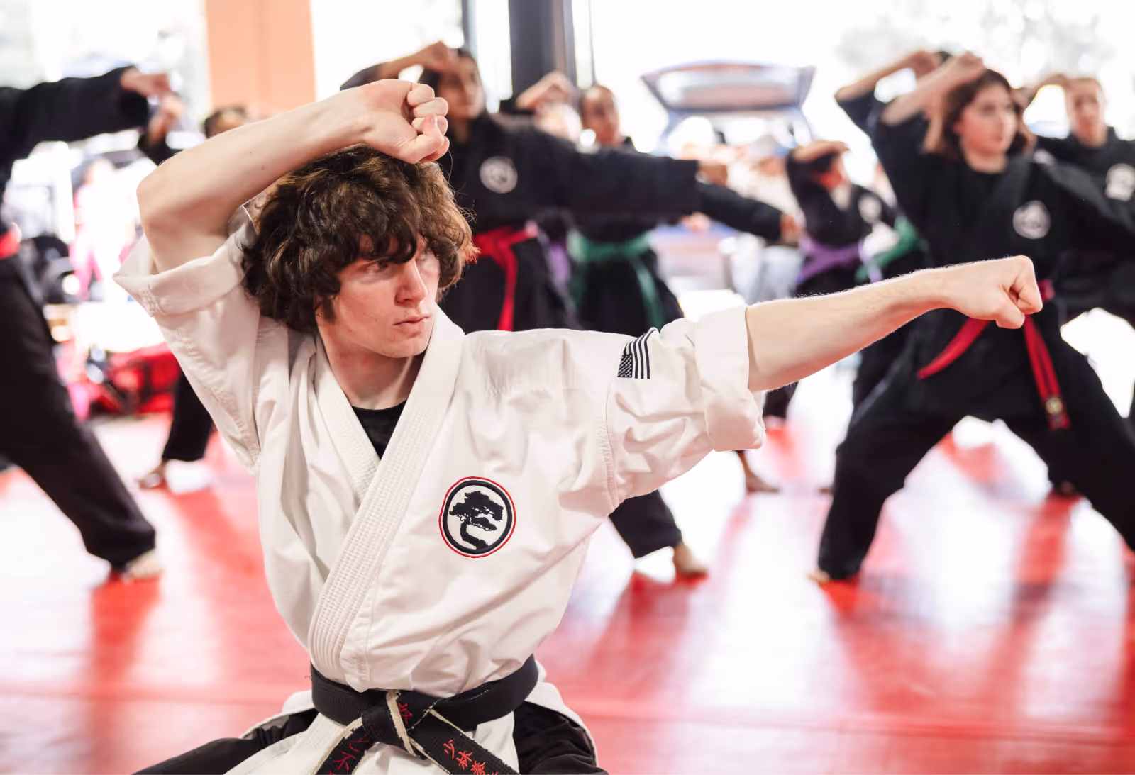 An adult group karate class practices their various forms and techniques in an organized class.