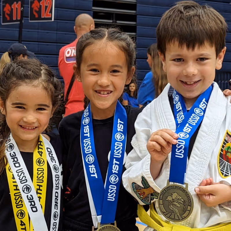 victorious tournament students pose for a picture with their gold and silver tournament medals.