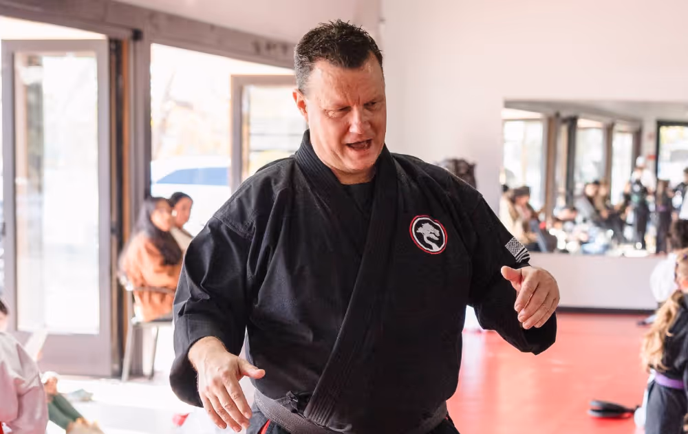 A karate instructor is explaining basic self defense skills to a group of grocery store employees.