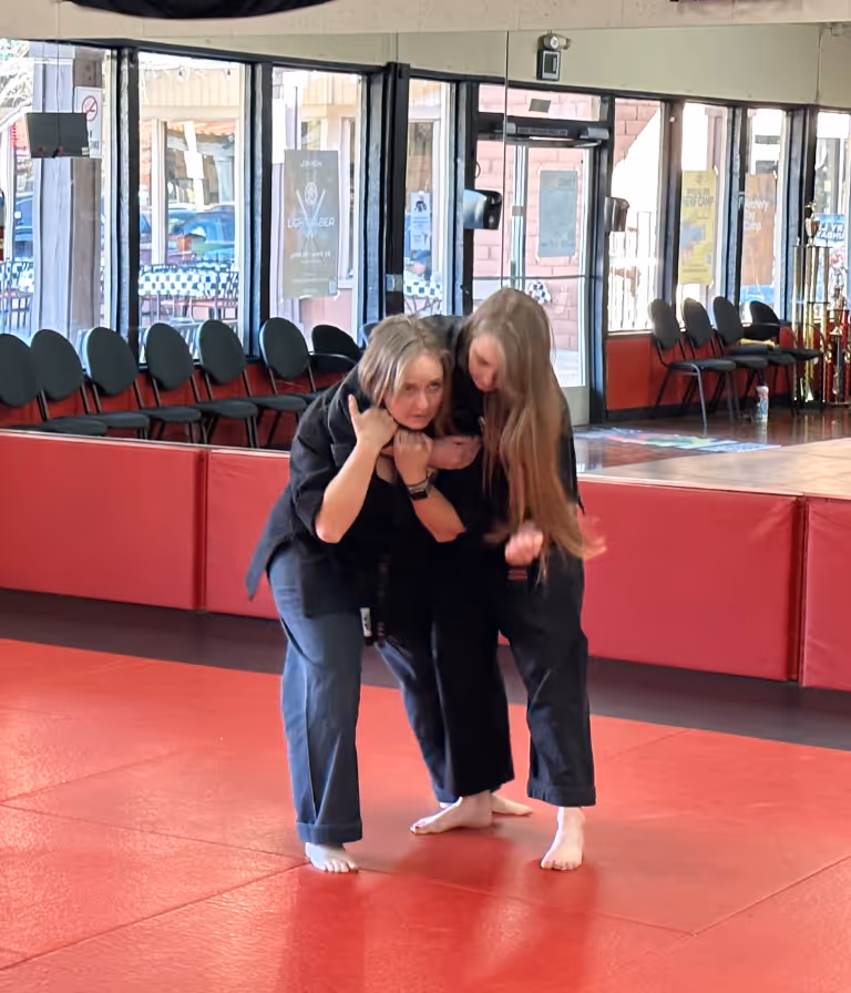 Two women practicing tactics to deal with grab holds during women's self defense class.