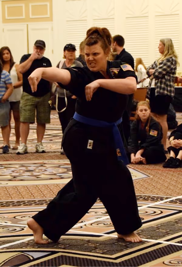 An adult karate student displaying her weapons forms with huge meteor hammers