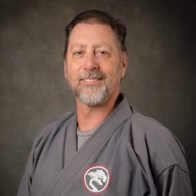 Head shot photo of Soke Jack Turner in their karate gi, smiling at the camera.