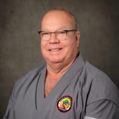 Head shot photo of Soke Richard Black in their karate gi, smiling at the camera.