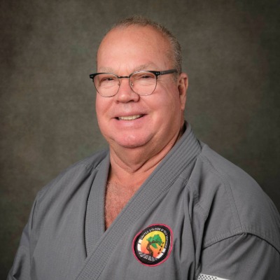 Head shot photo of Soke Richard Black in their karate gi, smiling at the camera.