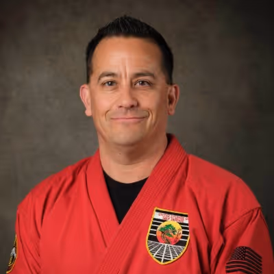 Head shot photo of Master Jose Rodriguez in their karate gi, smiling at the camera.