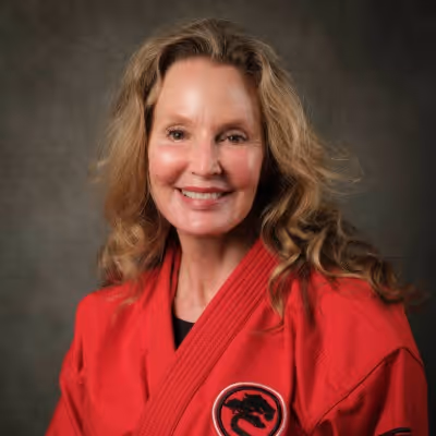 Head shot photo of Master Terri Martin in their karate gi, smiling at the camera.
