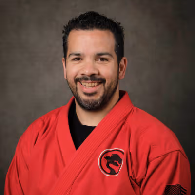 Head shot photo of Master Jose Rodriguez in their karate gi, smiling at the camera.
