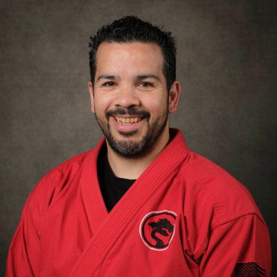 Head shot photo of Master Jose Rodriguez in their karate gi, smiling at the camera.