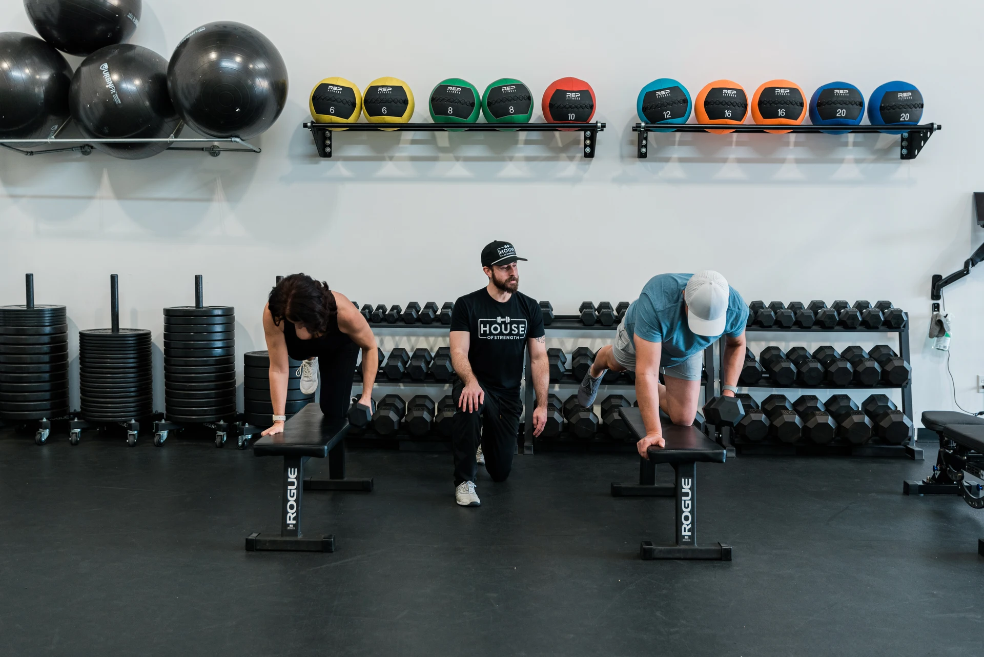 House of Strength coach guiding an adult client through a strength exercise at the Windsor training facility.