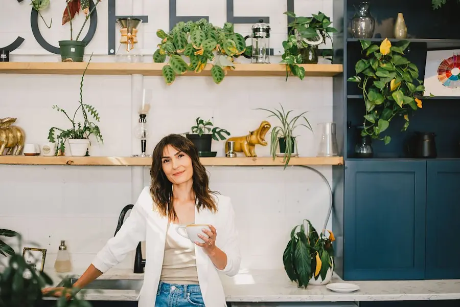 Client Raush of Savvy Assistant Co smiling while holding a cup of coffee and sharing her thoughts and honest opinions on her monthly bookkeeping support from Coyne Bookkeeping