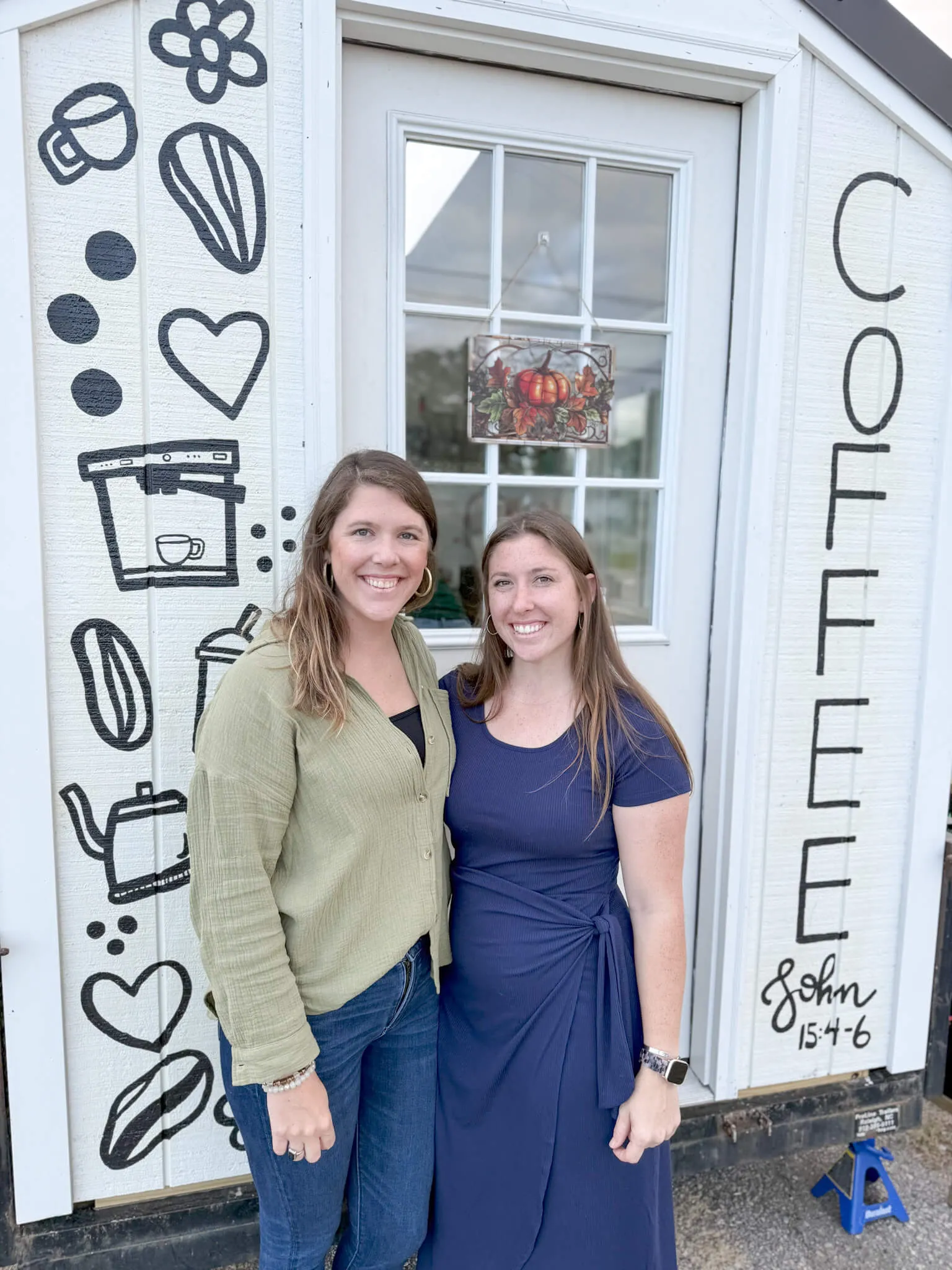 Owners of Moss and Ivy co smiling in front of their coffee shop