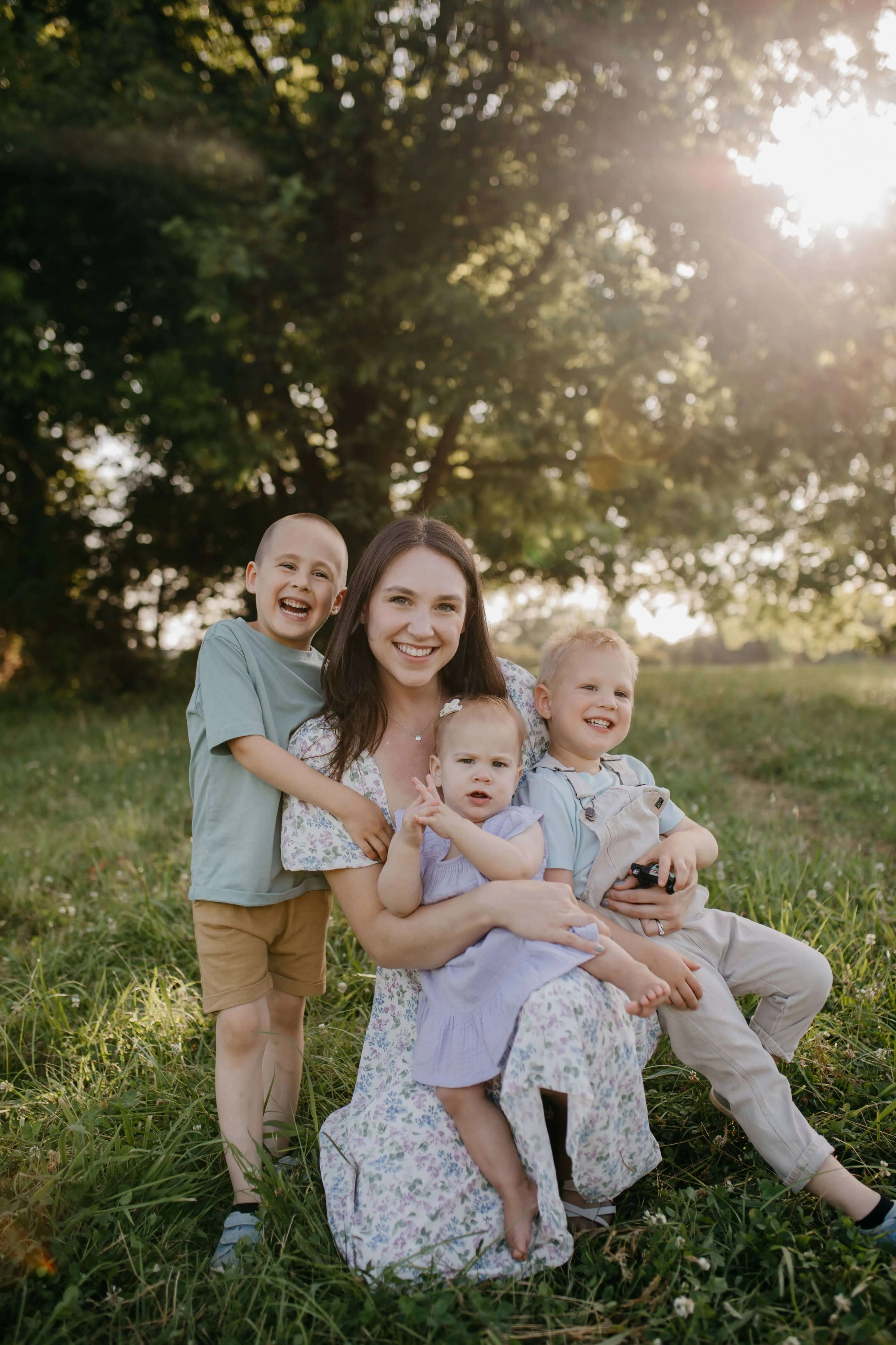 Taylor and Jacob Coyne holding hands with their kids in an open field