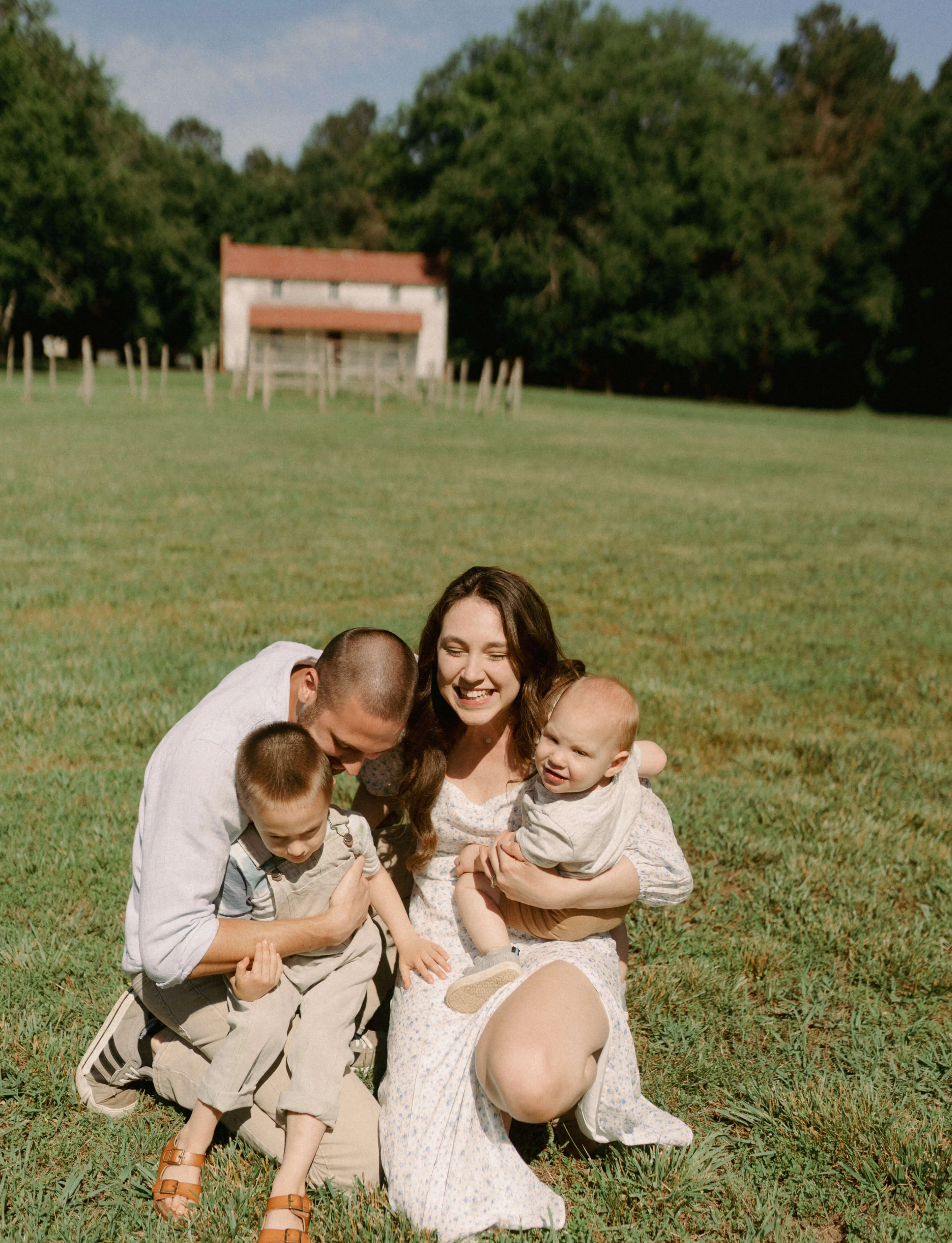 Taylor and Jacob Coyne hugging their kids outside in an open field
