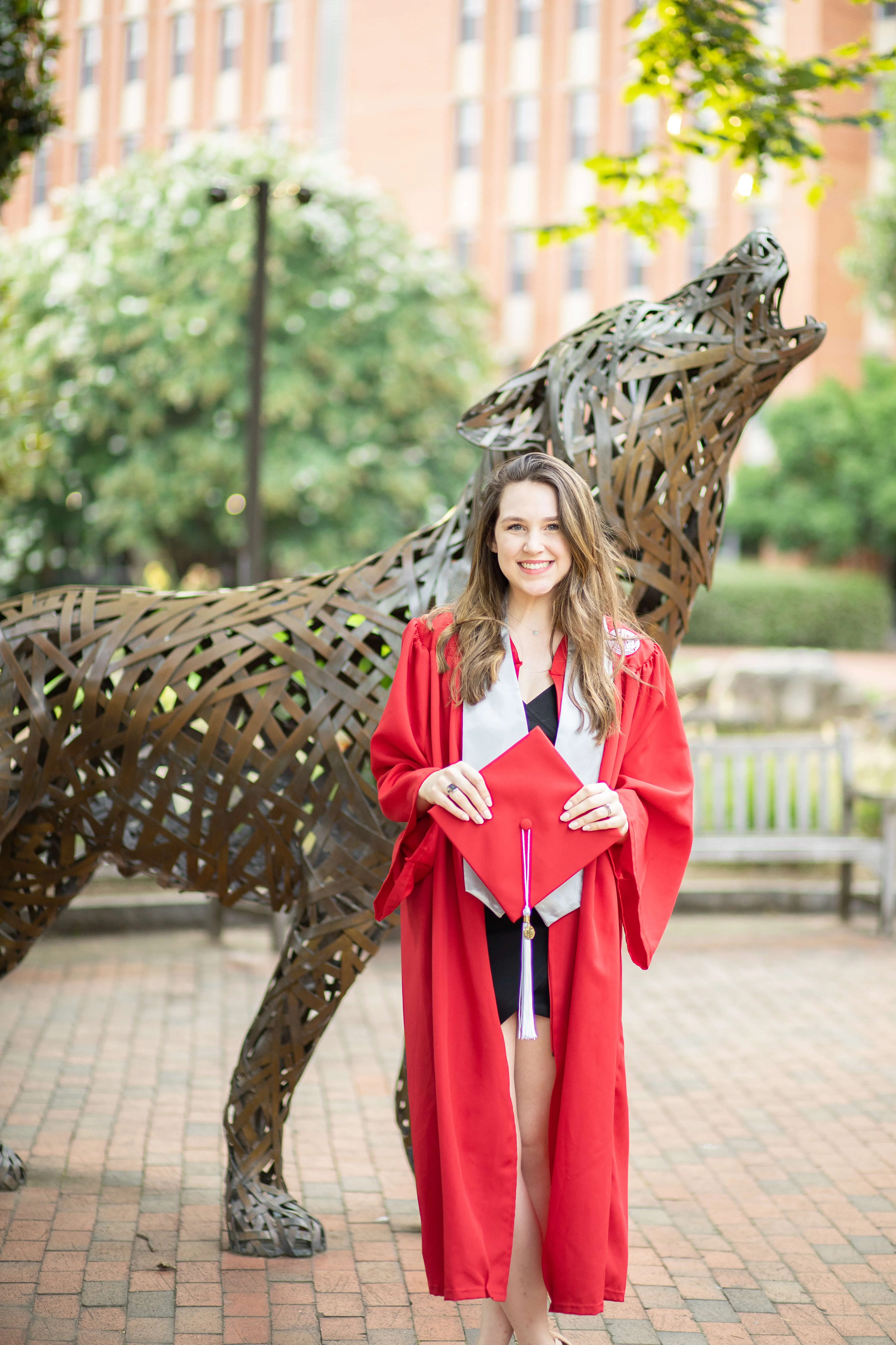 Taylor Coyne standing outside NC State University in her graduation gown
