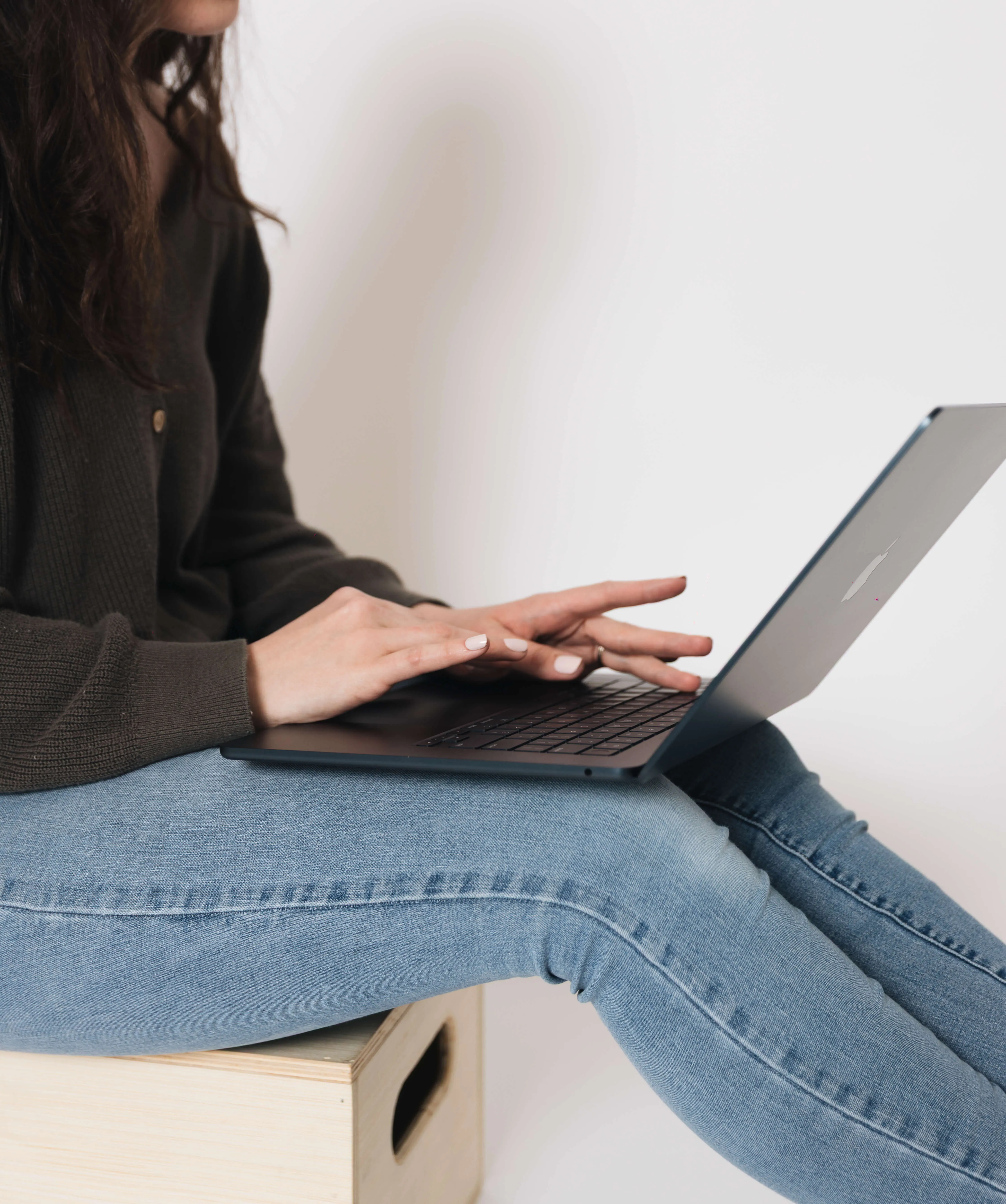 Bookkeeper for entrepreneurs sitting on the floor and taking notes for a client's books.