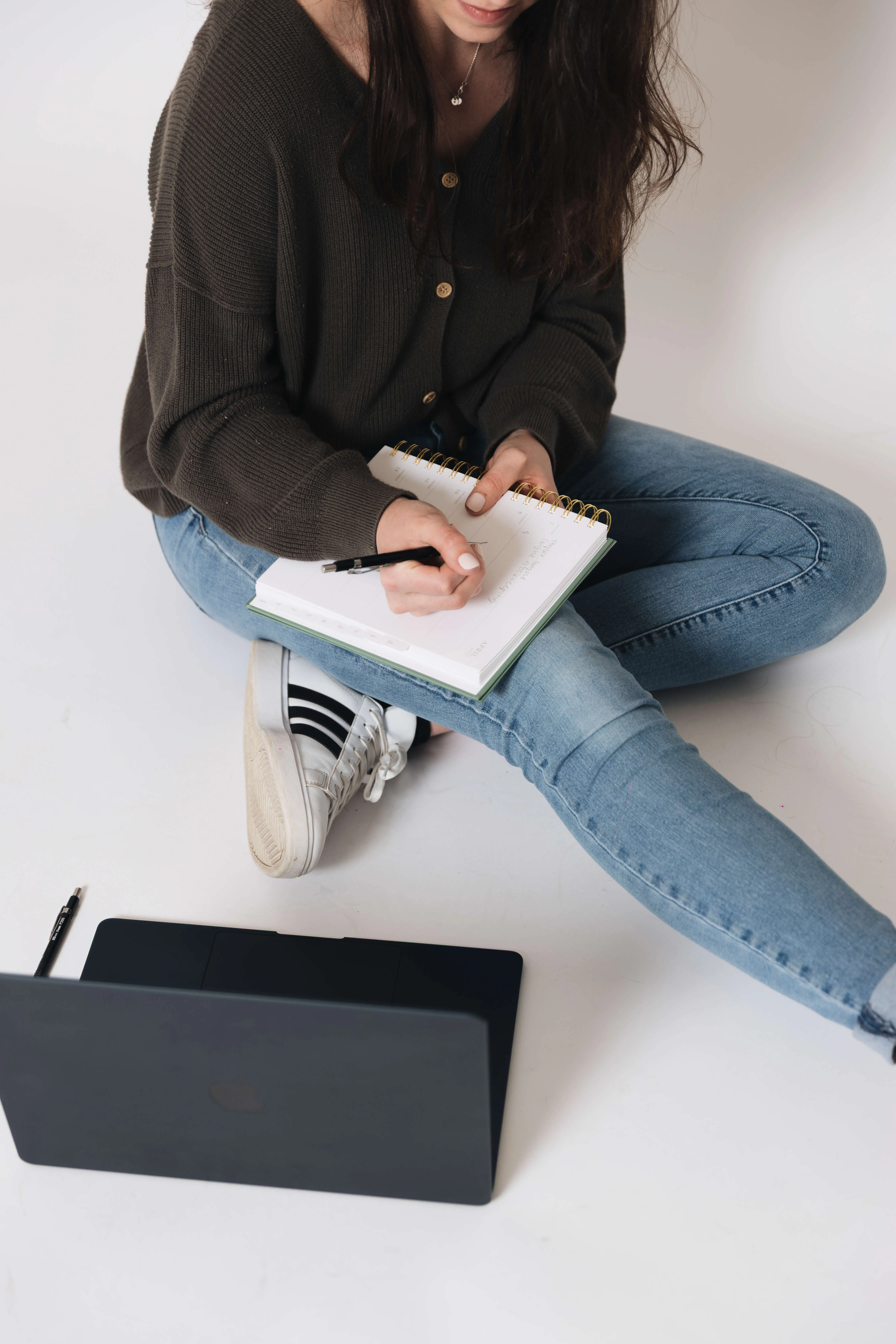 Taylor sitting on the floor, writing in a notebook