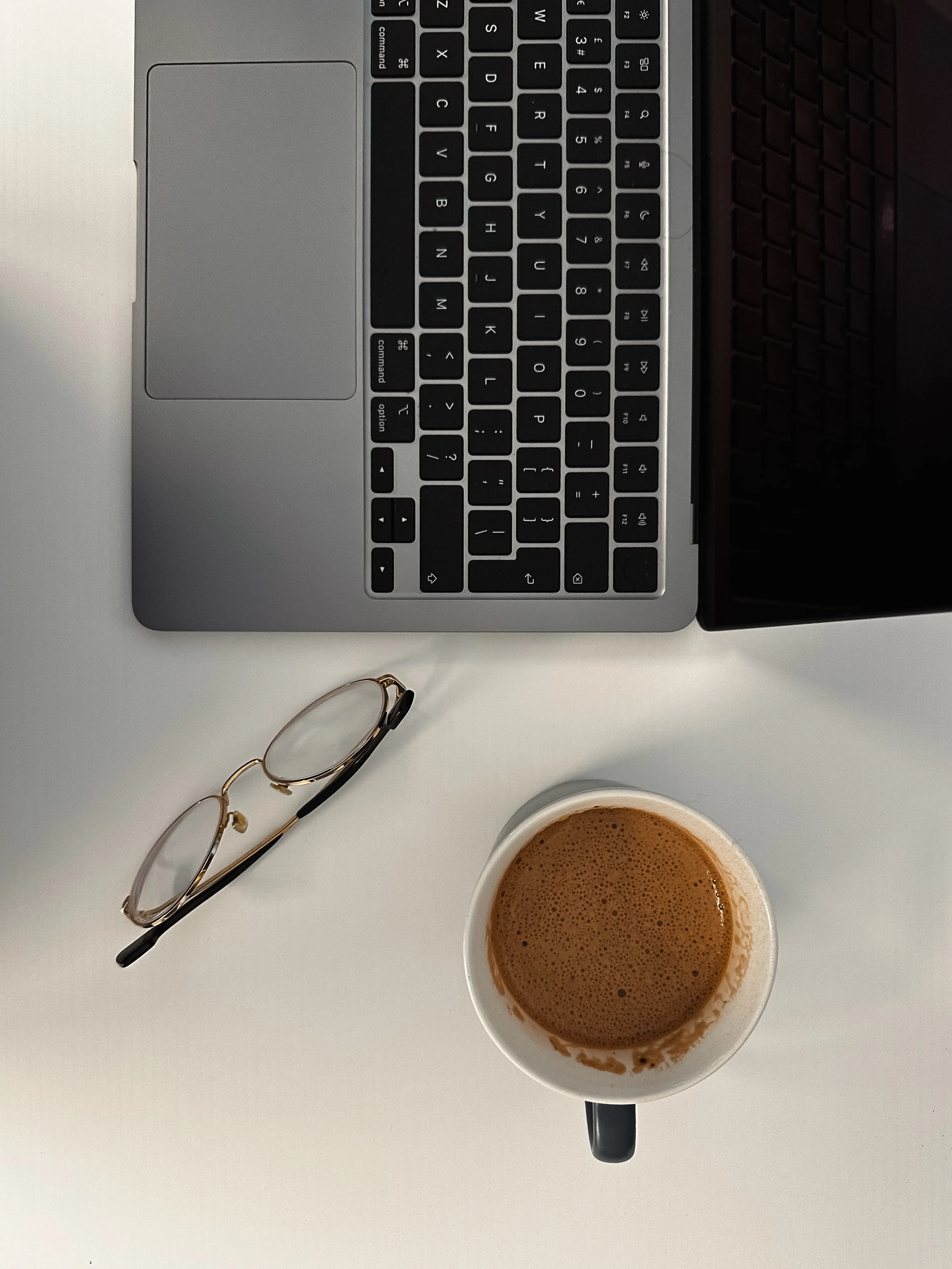 Virtual bookkeeper workspace with laptop and coffee, providing organized bookkeeping services for small business owners.