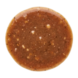 Rich brown lamb gravy with a glossy finish and herb flecks, served in a round portion on a white background