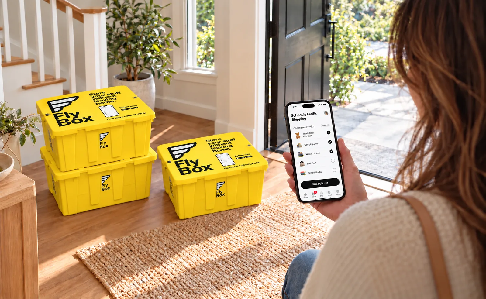FlyBoxes with correct toppers and stickers by a sunny doorway as a customer schedules shipping in the app