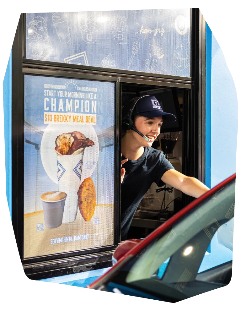 a photo of a woman serving orders on the yiros shop drive thru